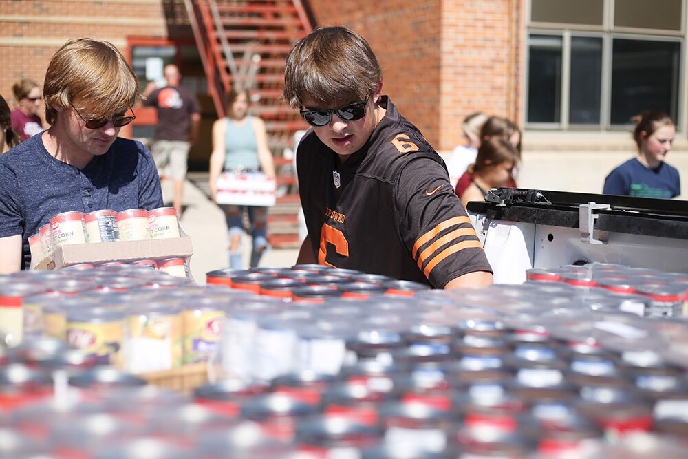 Jackson Moon makes a spot for Fischer Kirven to load a box into the back of his truck